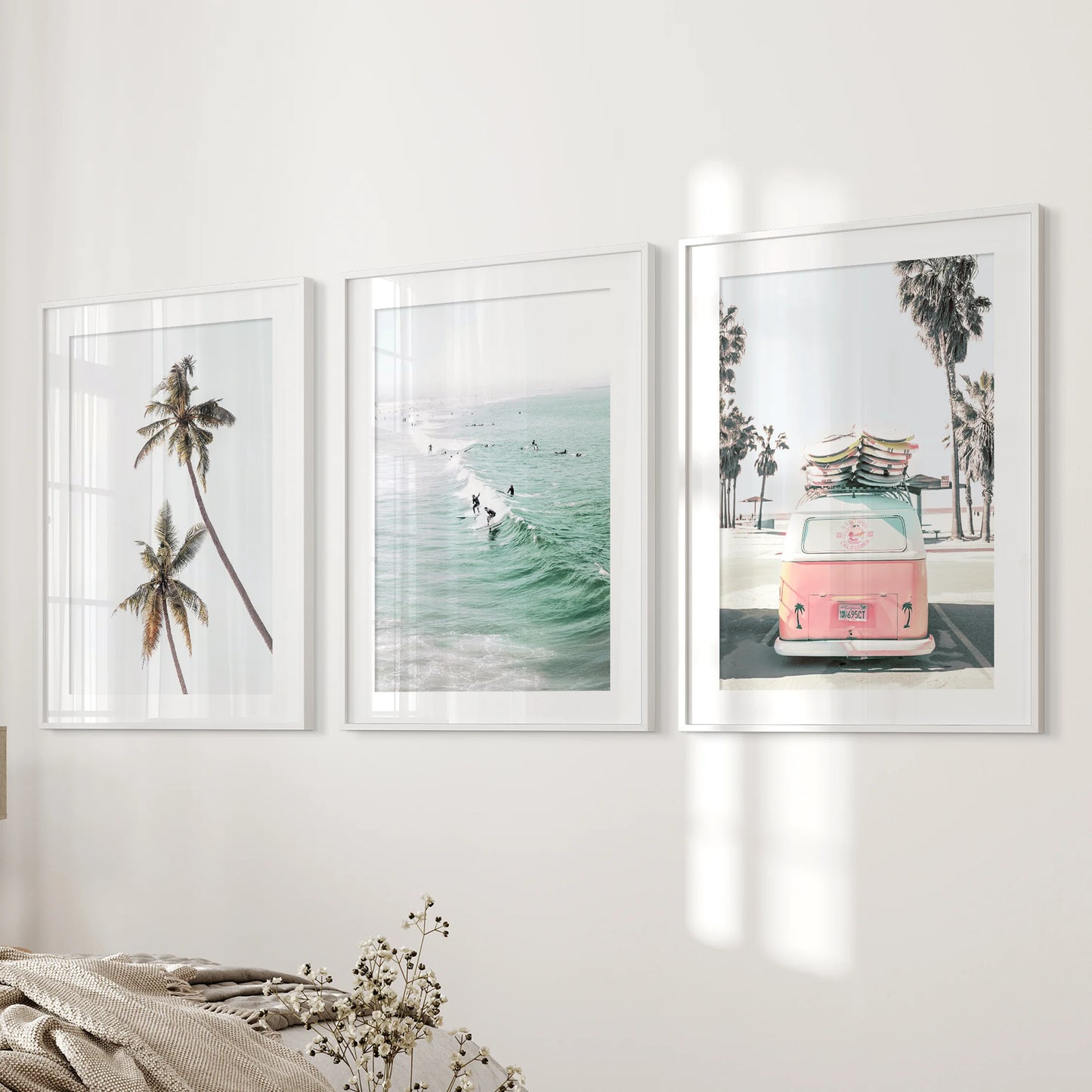 Ocean-surf wall art styled as a 3-print set soothes the bedroom, each white-matted frame evenly spaced along the feature wall.
