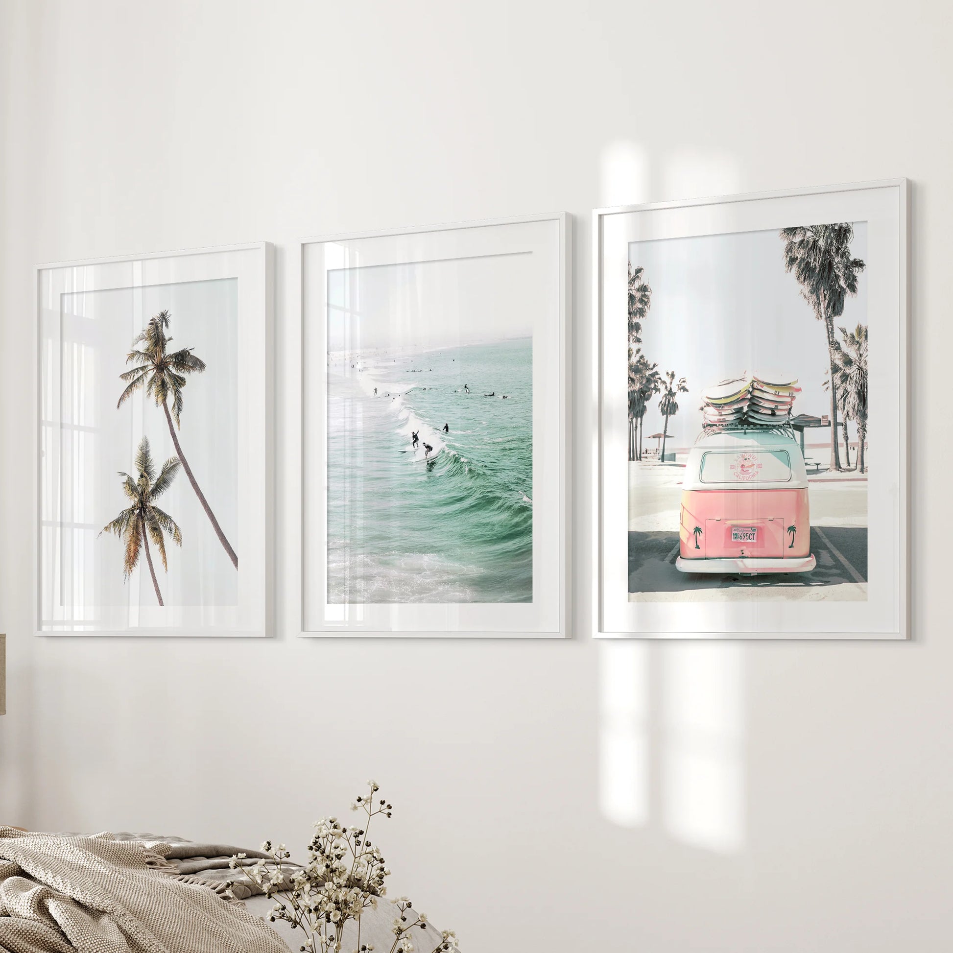 Ocean-surf wall art styled as a 3-print set soothes the bedroom, each white-matted frame evenly spaced along the feature wall.