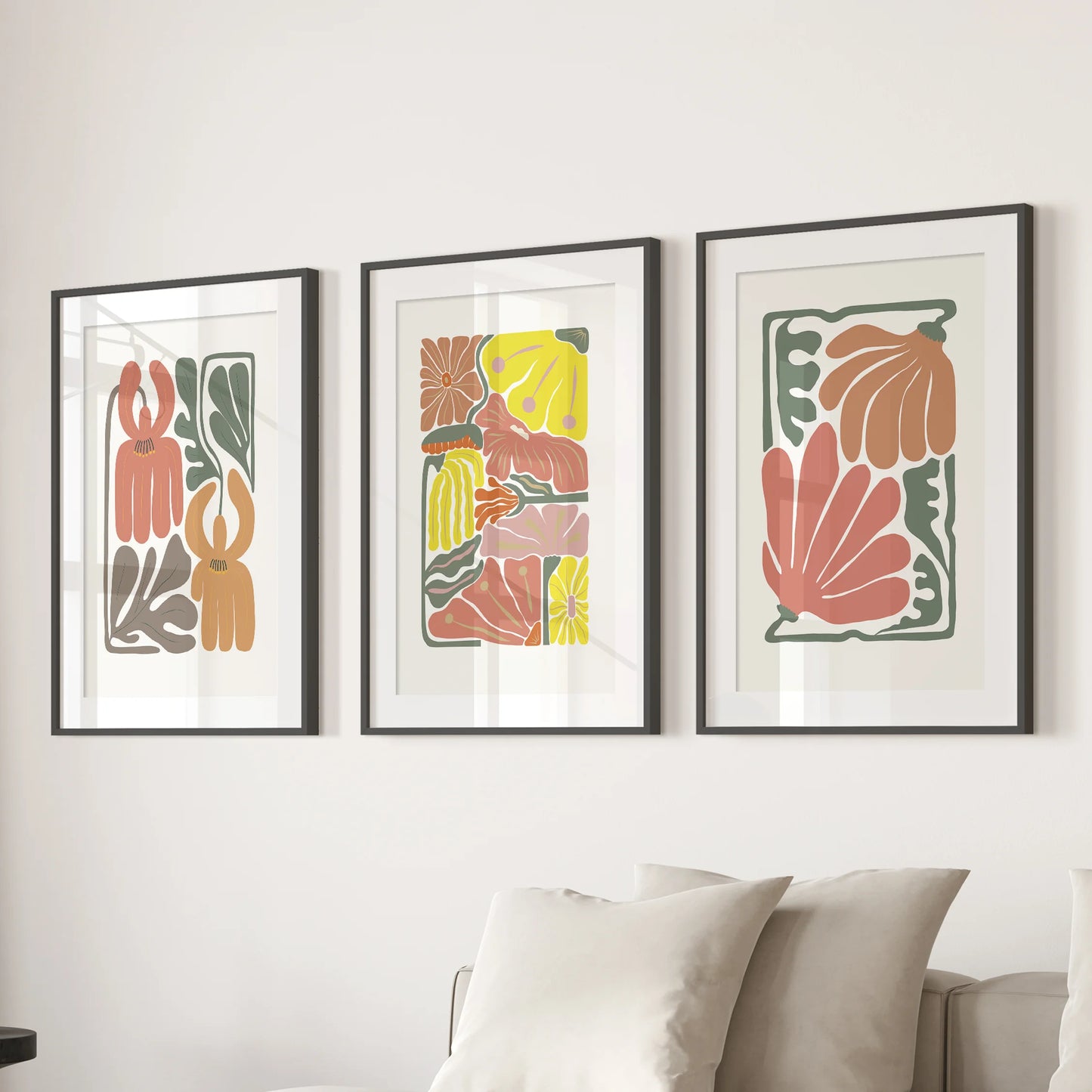 Modern floral illustrations, a refined 3-piece wall art set, stretch behind the sitting-room couch in black matted frames with a gallery feel.