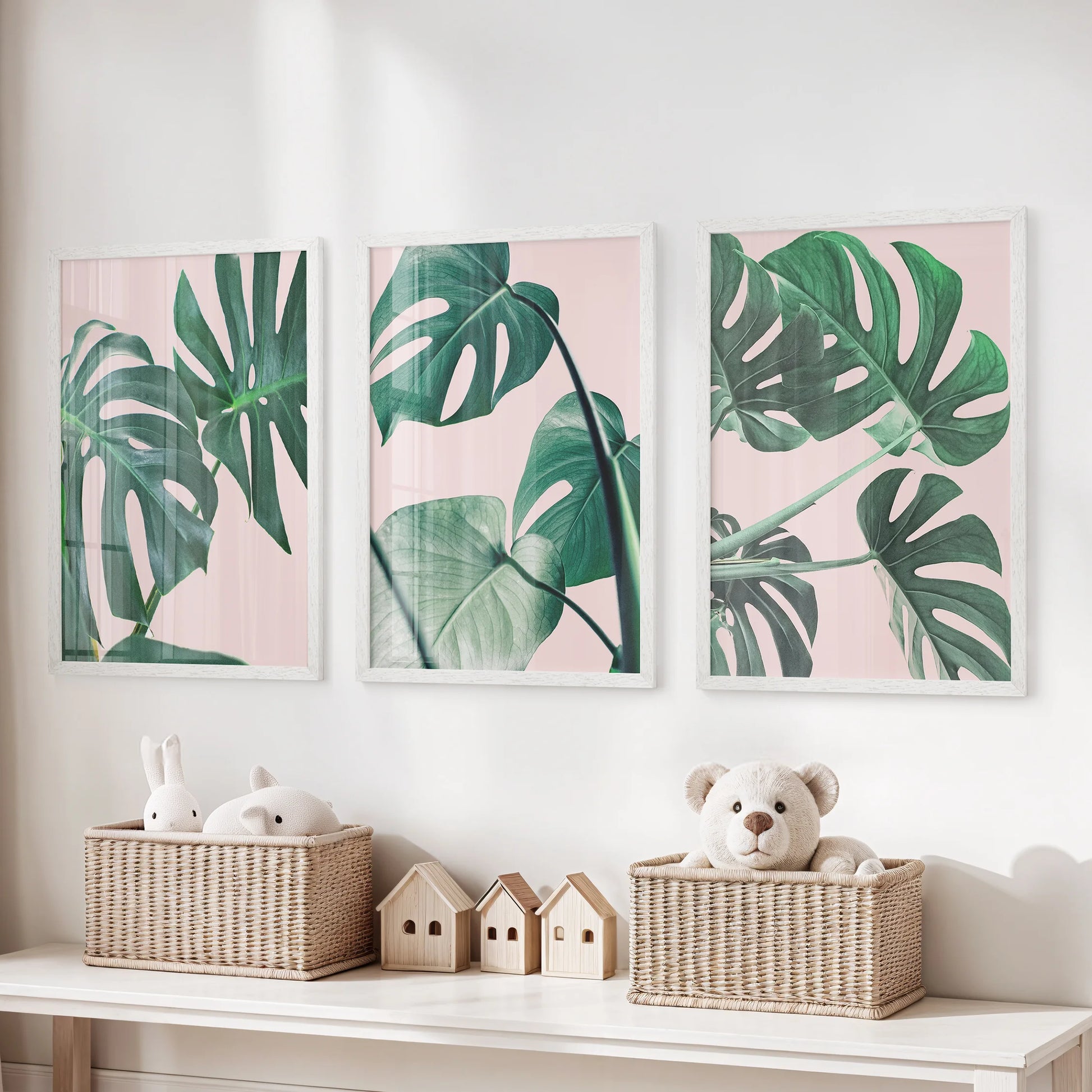 Monstera leaf close-ups gallery set of three white-framed prints makes playful yet tidy wall art for a children’s room, mixing blush pink with fresh greens.