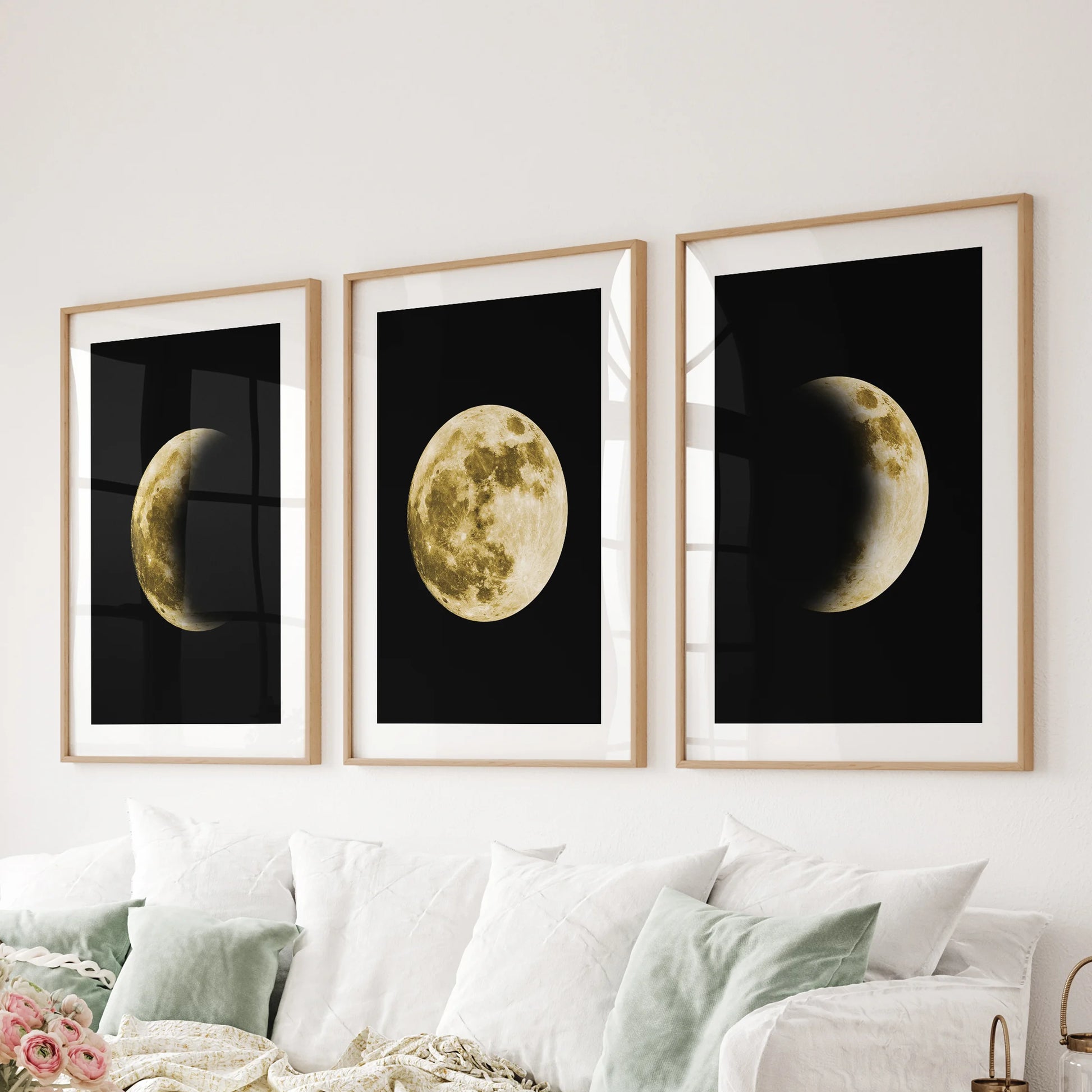Black-and-gold lunar design, a 3 poster bundle in oak framed prints with mats, spans the sitting room wall behind the sofa for striking modern art.