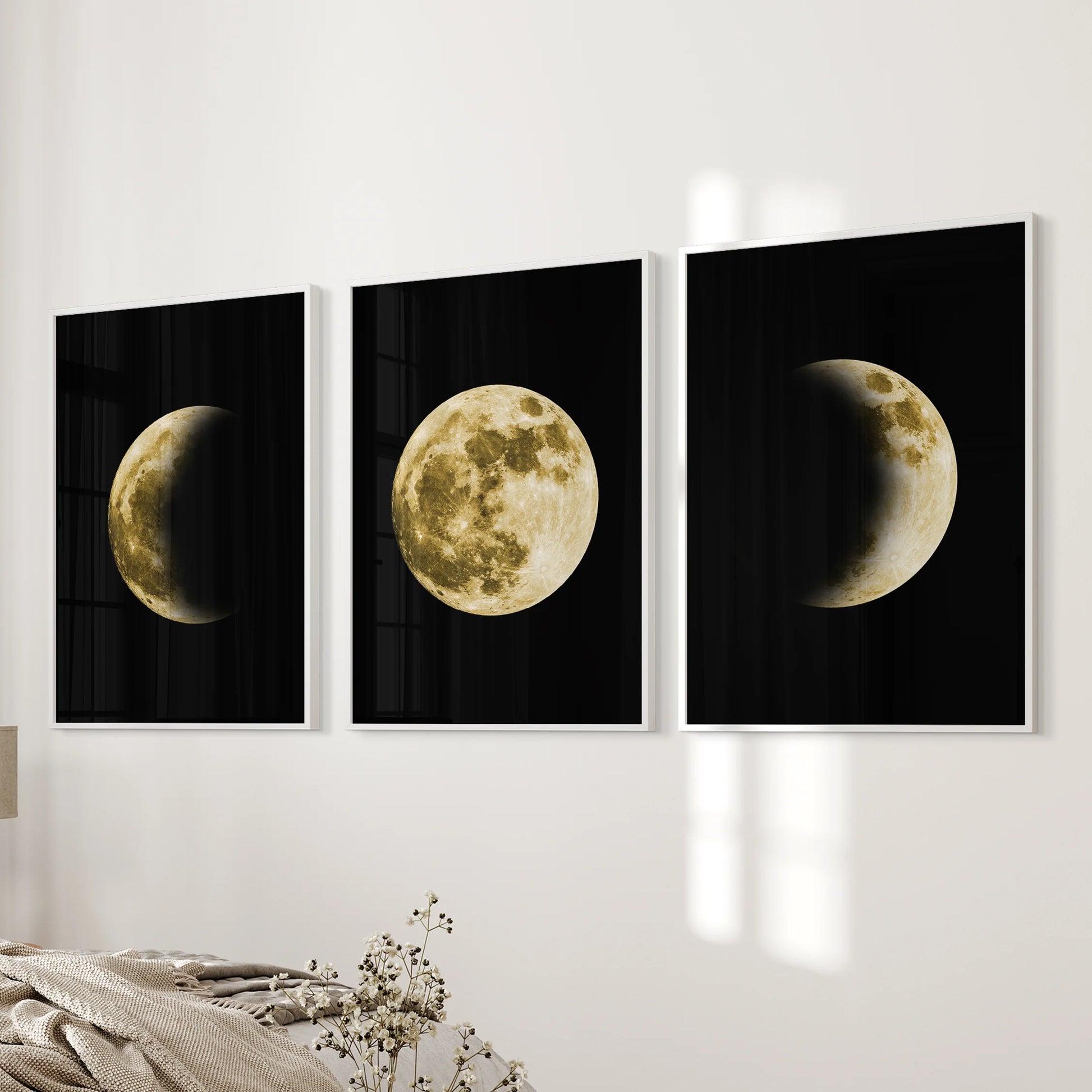 Three white-framed moon prints line the bedside wall, this soft lunar artwork bathing the bedroom in a clean, dreamlike glow.