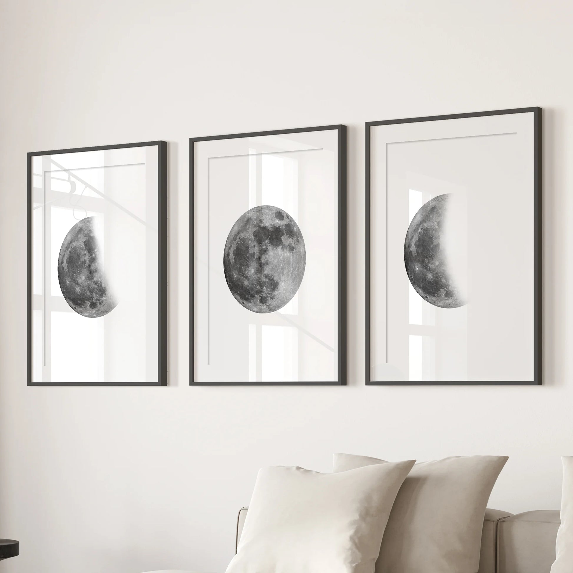 Lunar cycle trio gallery wall set of 3, matted in wide-border black frames and hung above the couch to ground the family room with modern celestial art.