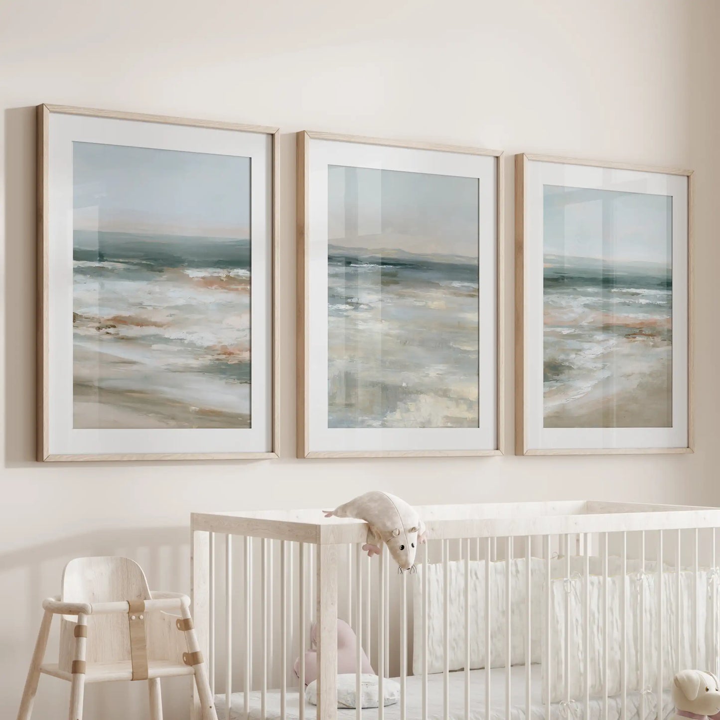 Oak-framed shoreline prints, a set of three with mats, hang above the crib to fill the nursery with soft ocean hues and hush-quiet warmth.
