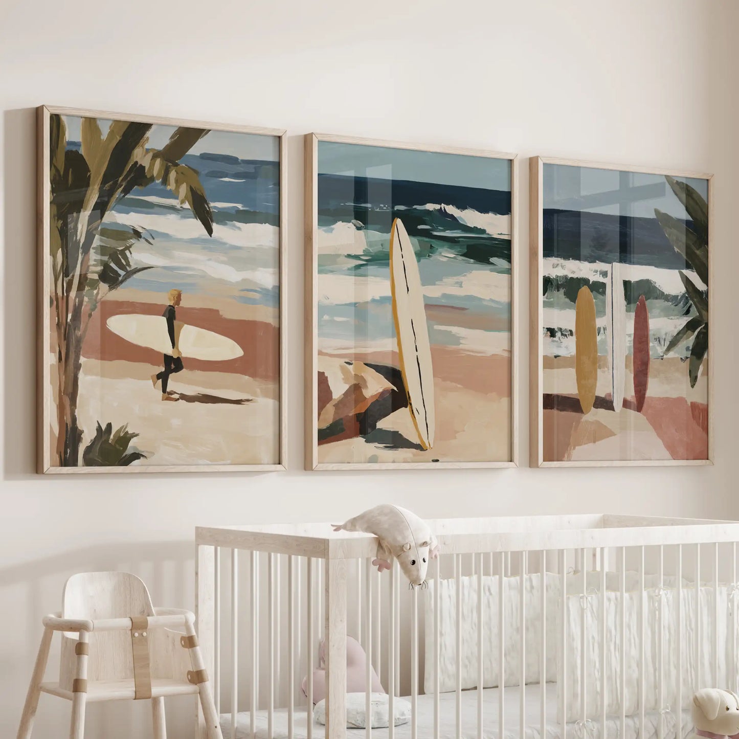 A three-piece seaside wall decor set in natural wood frames floats above the crib, softly mixing aqua surf, greens, and sunlit sand.