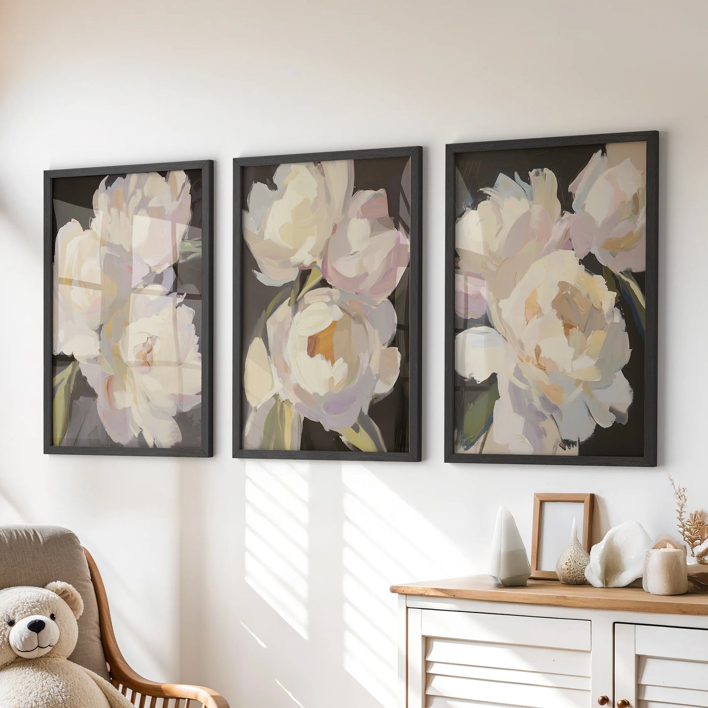 Above the playroom dresser, three antique-style flower prints in matte black frames soften the corner with rosy, nostalgic wall art.