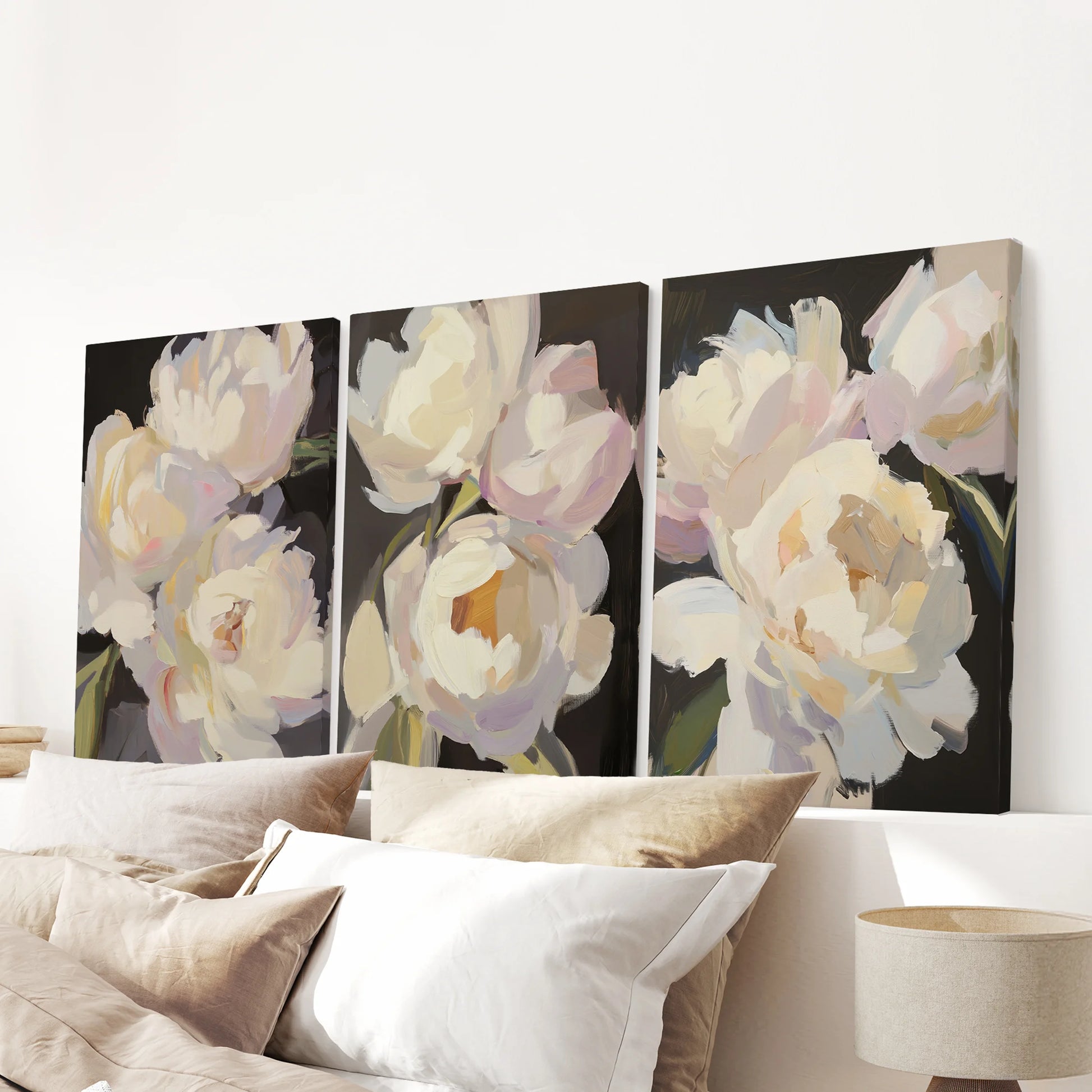 Three canvas prints of pink and white peonies float over the bedroom bed, their dark backdrop making each soft bloom quietly glow.