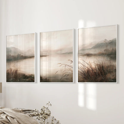Set of three painterly nature wall art prints in white frames, hanging next to the bed in a bedroom.