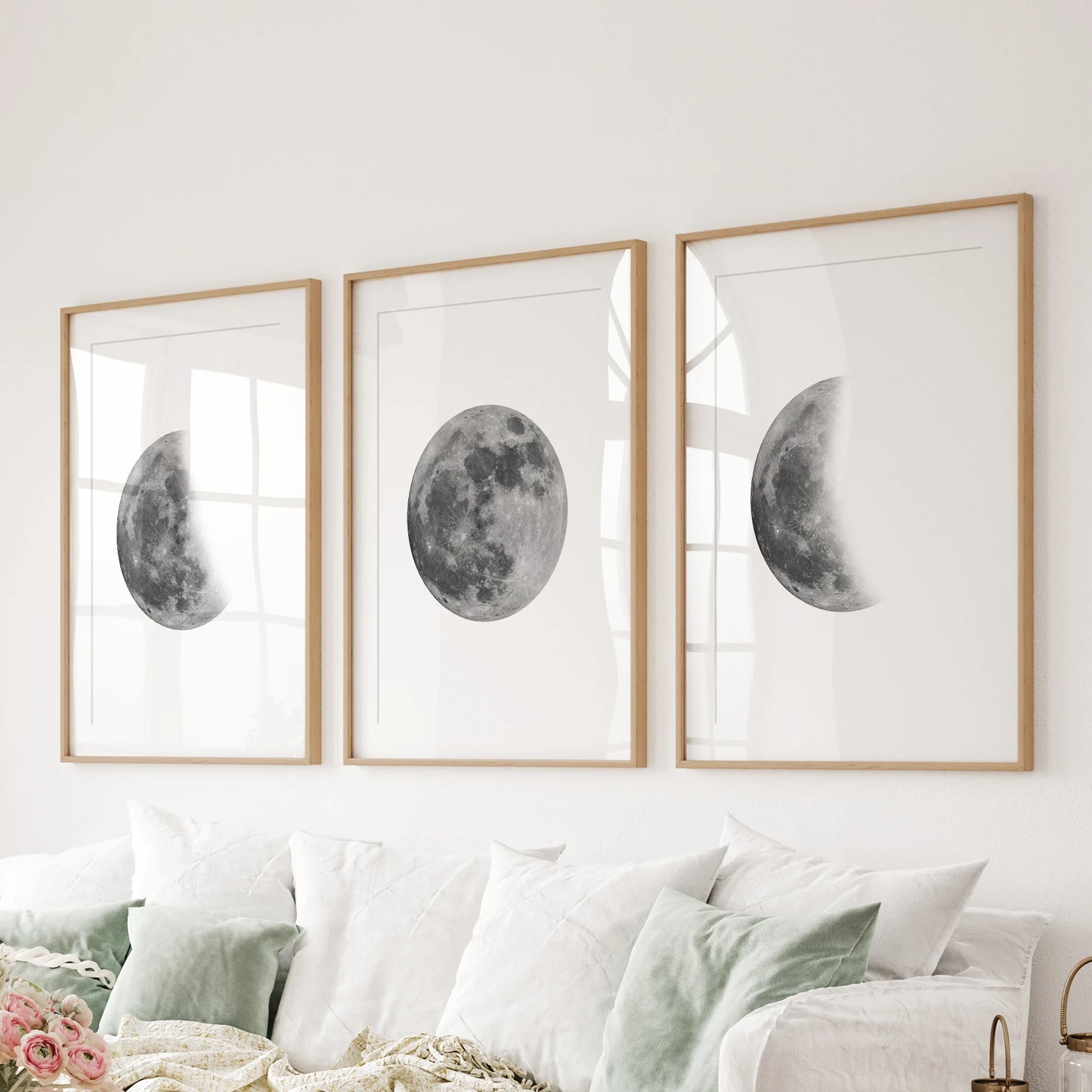 Lunar cycle trio 3-piece art wall, matted in oak frames, lines the wall behind the couch to ground the family room with calm, modern moon art.