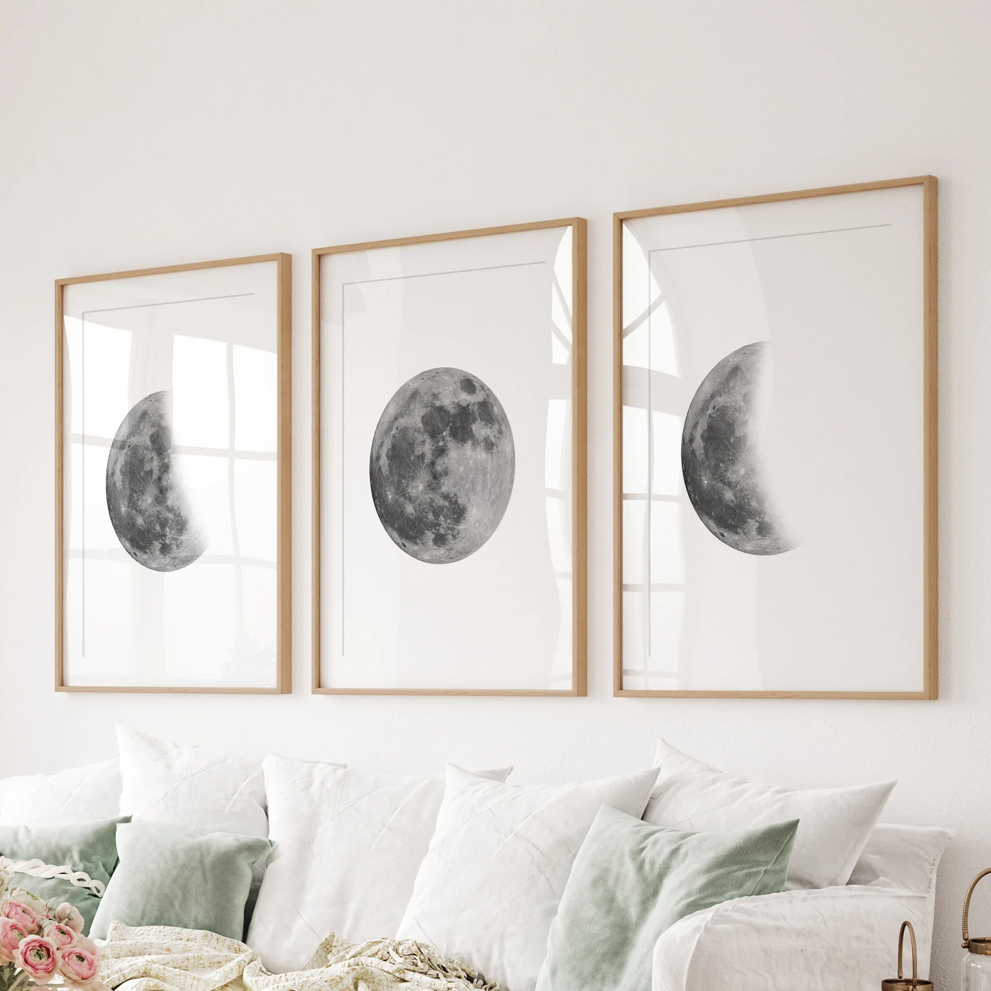 Lunar cycle trio 3-piece art wall, matted in oak frames, lines the wall behind the couch to ground the family room with calm, modern moon art.