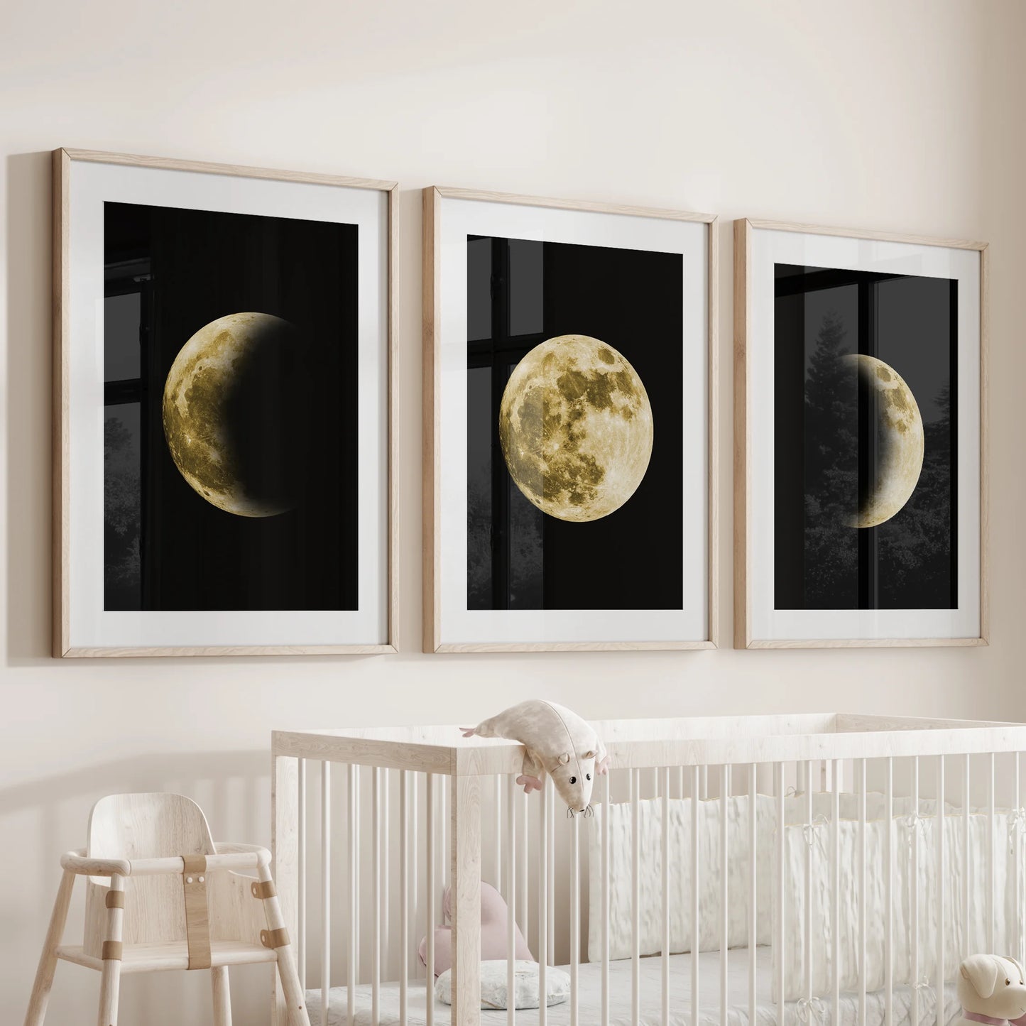 Over the nursery bassinet hangs a set of three wood-framed moon posters with mats, giving the wall soft, moonlit serenity.