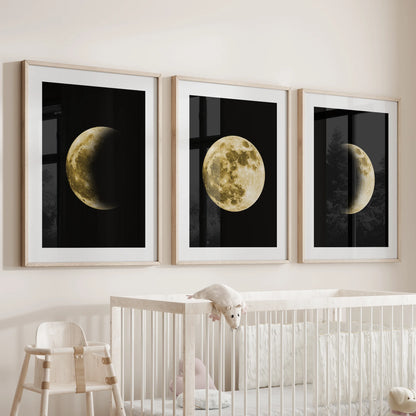 Over the nursery bassinet hangs a set of three wood-framed moon posters with mats, giving the wall soft, moonlit serenity.