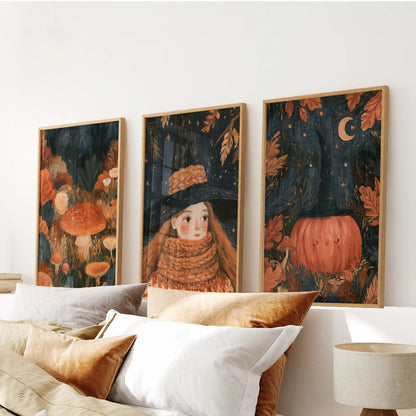 A set of three wall prints depicts a storybook cottagecore forest, floating above the bedroom headboard in slim wood frames.