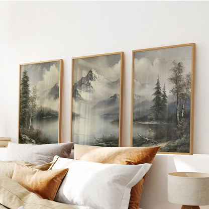Muted alpine scenery three-print wall art set in thin wood frames, arranged above the headboard in a bedroom.