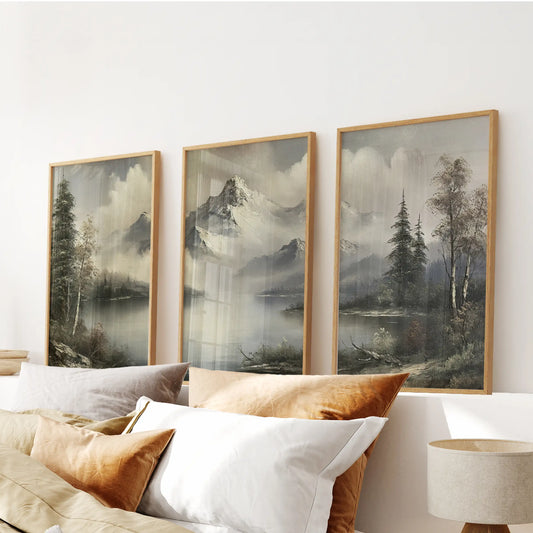 Muted alpine scenery three-print wall art set in thin wood frames, arranged above the headboard in a bedroom.
