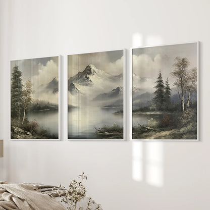 Wall art trio featuring muted alpine scenery in white frames, displayed in a horizontal row on a bedroom wall beside the bed.