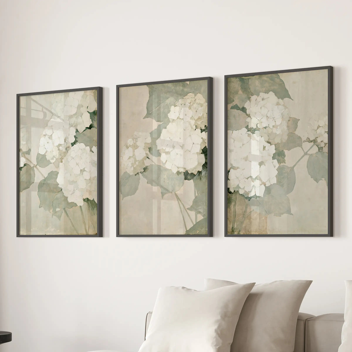 Three-print wall art set of vintage garden botanicals in black frames, displayed behind a sofa in the family room.
