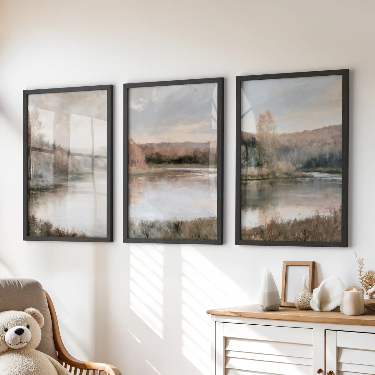 A set of three nature prints showing a muted shoreline and trees rests in black frames above the kids room dresser, adding gentle autumn color.