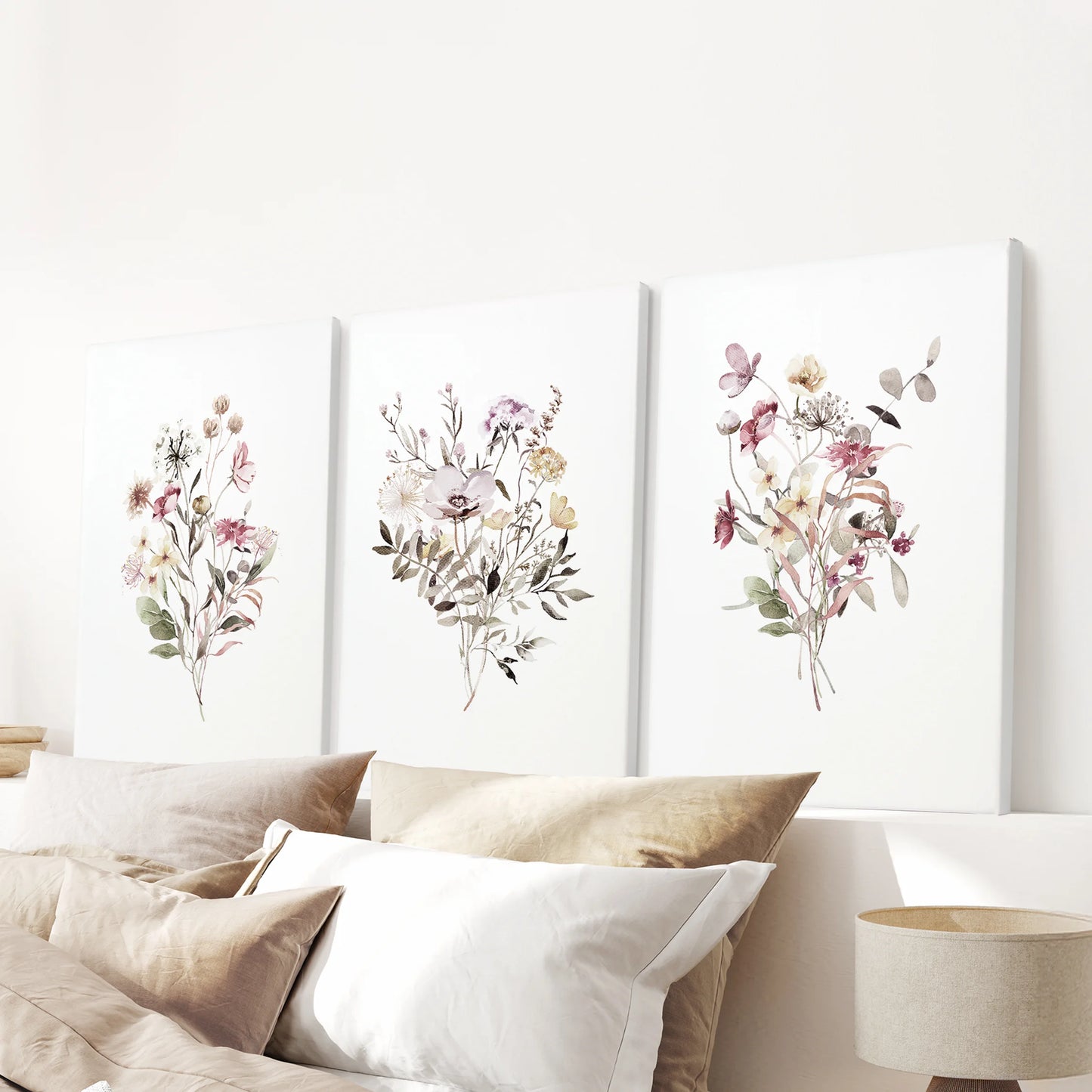 Three wrapped-canvas botanical panels hang over the bed, completing a modern, serene wall moment in the bedroom.