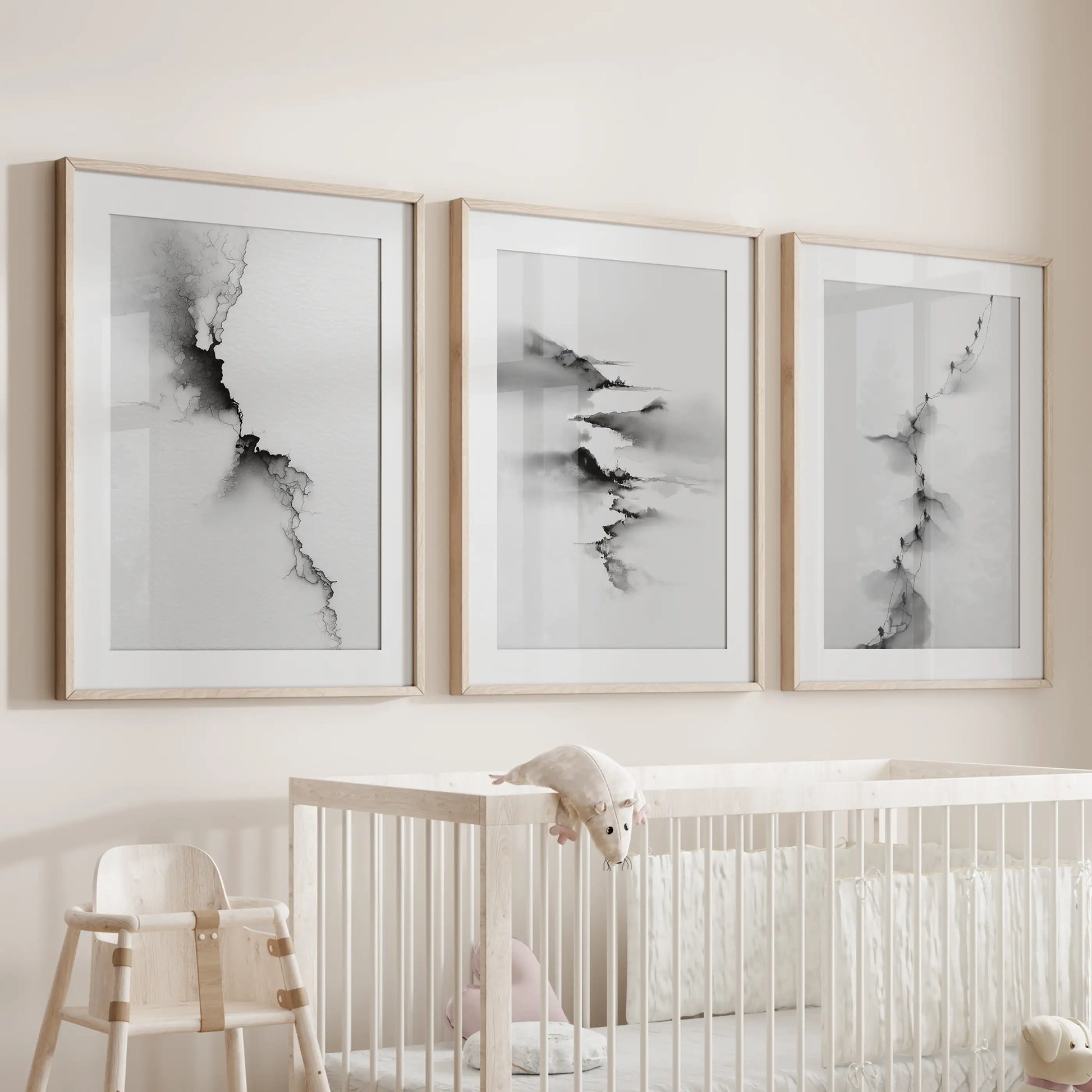 Calming scenic art triptych, 3-piece wall art in light wood frames with mats, rests above the bassinet to create a gentle monochrome nook.