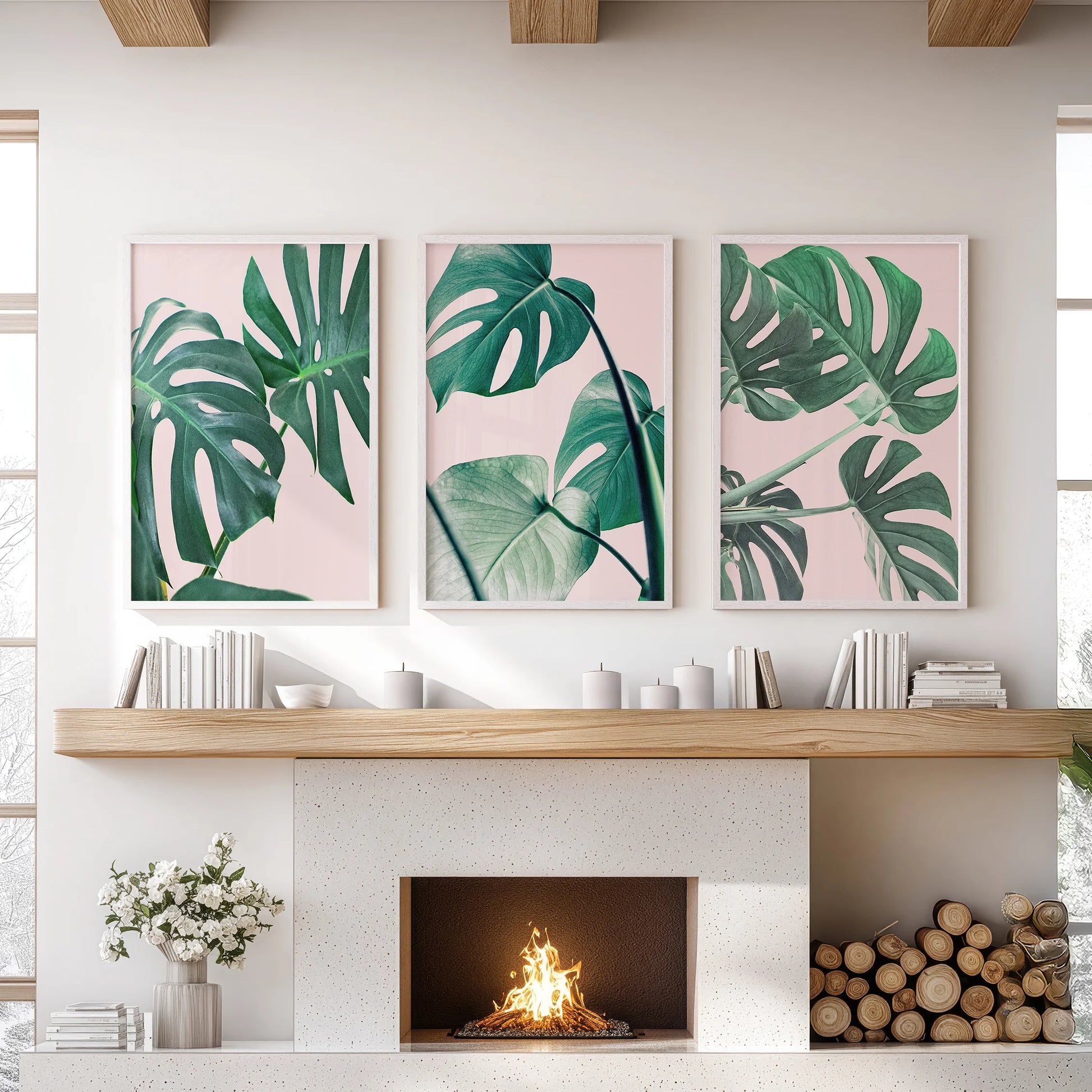 A calm trio of white-framed botanical artworks rests above the sitting-room mantel, bringing quiet boho greenery without clutter.