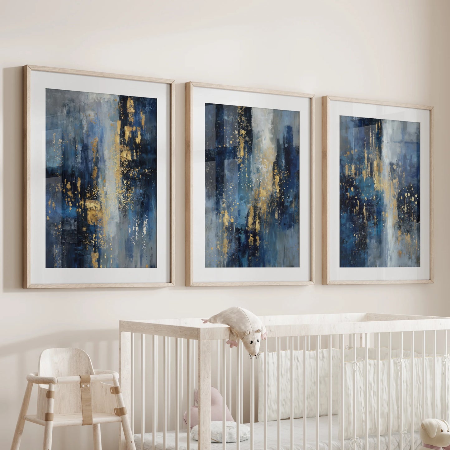 Natural wood-framed wall art in blue and gold hues hangs as a 3-piece set over the crib, bringing gentle calm to the infant room.