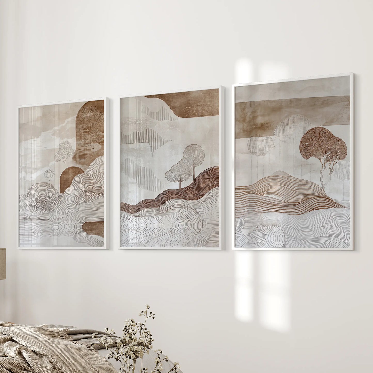 A white-framed three-piece wall art set of neutral shapes rests beside the bed, echoing soft, modern geometry in the bedroom.