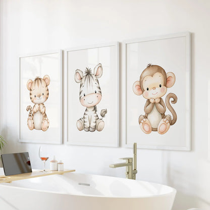 White frames surround three baby animal prints above a freestanding bathtub; the monkey at right has a curled tail.