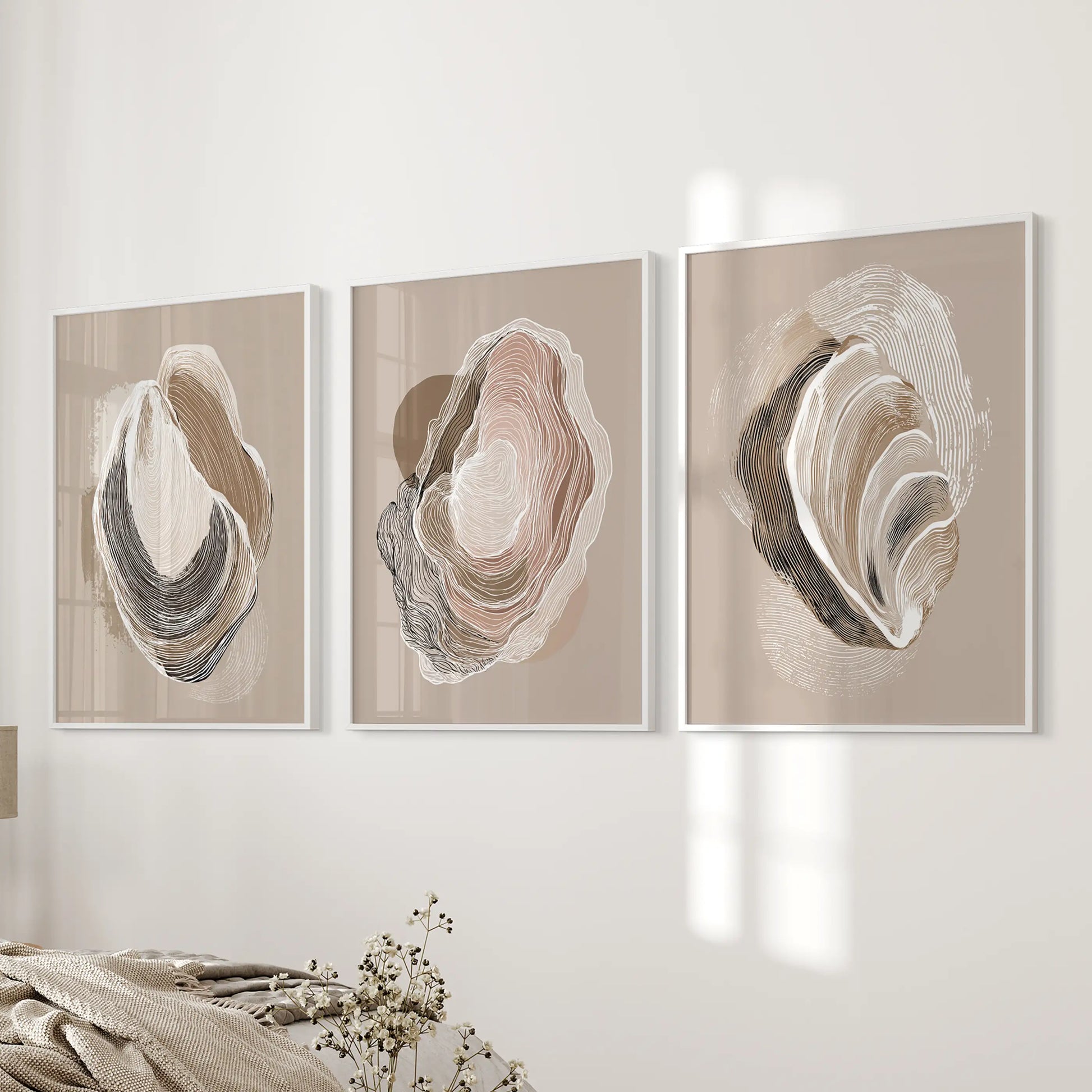 Coastal oyster drawings, a 3-piece artwork set in clean white frames, center the bedroom wall with neutral beige tones and airy seaside simplicity.