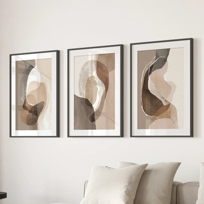 Earth-tone geometric prints three-piece set, in black frames with mats, hangs over the sectional to calm a sitting room with layered neutrals.