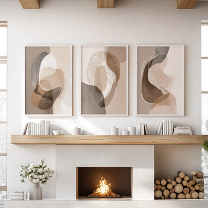 Neutral abstract wall art poster set of 3, in white frames, crowns the fireplace in a sitting room and brings airy earth tones to the mantel.