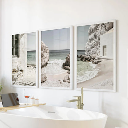 Neutral coastal beach prints, a framed print trio set in white frames, sits over the bathtub to introduce spa-like calm and light to the bathroom.