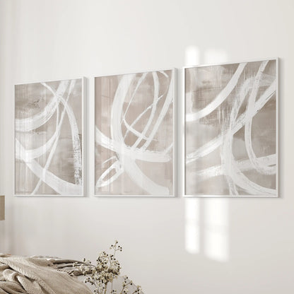 Three white-framed minimalist prints of soft organic shapes balance the bedside wall, bringing warm neutral calm to the bedroom.