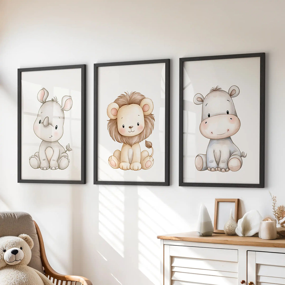 A pale rhino, golden lion and gray hippo sit on white backgrounds in three black-framed prints above a dresser.