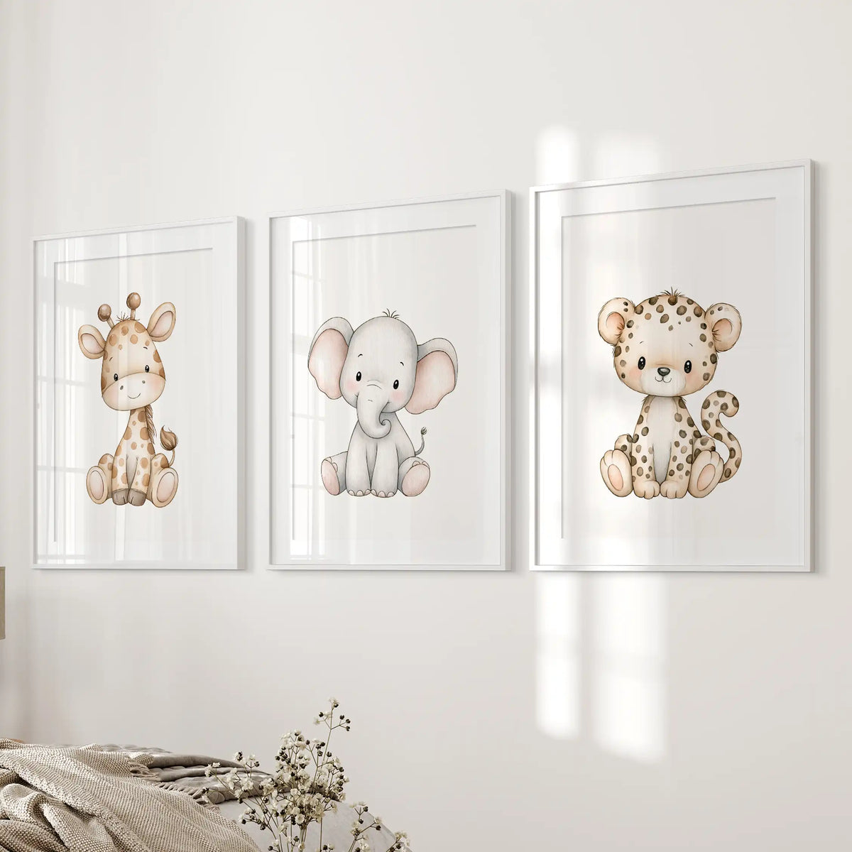 Beside a bed, three baby animal prints sit in white frames with mats.