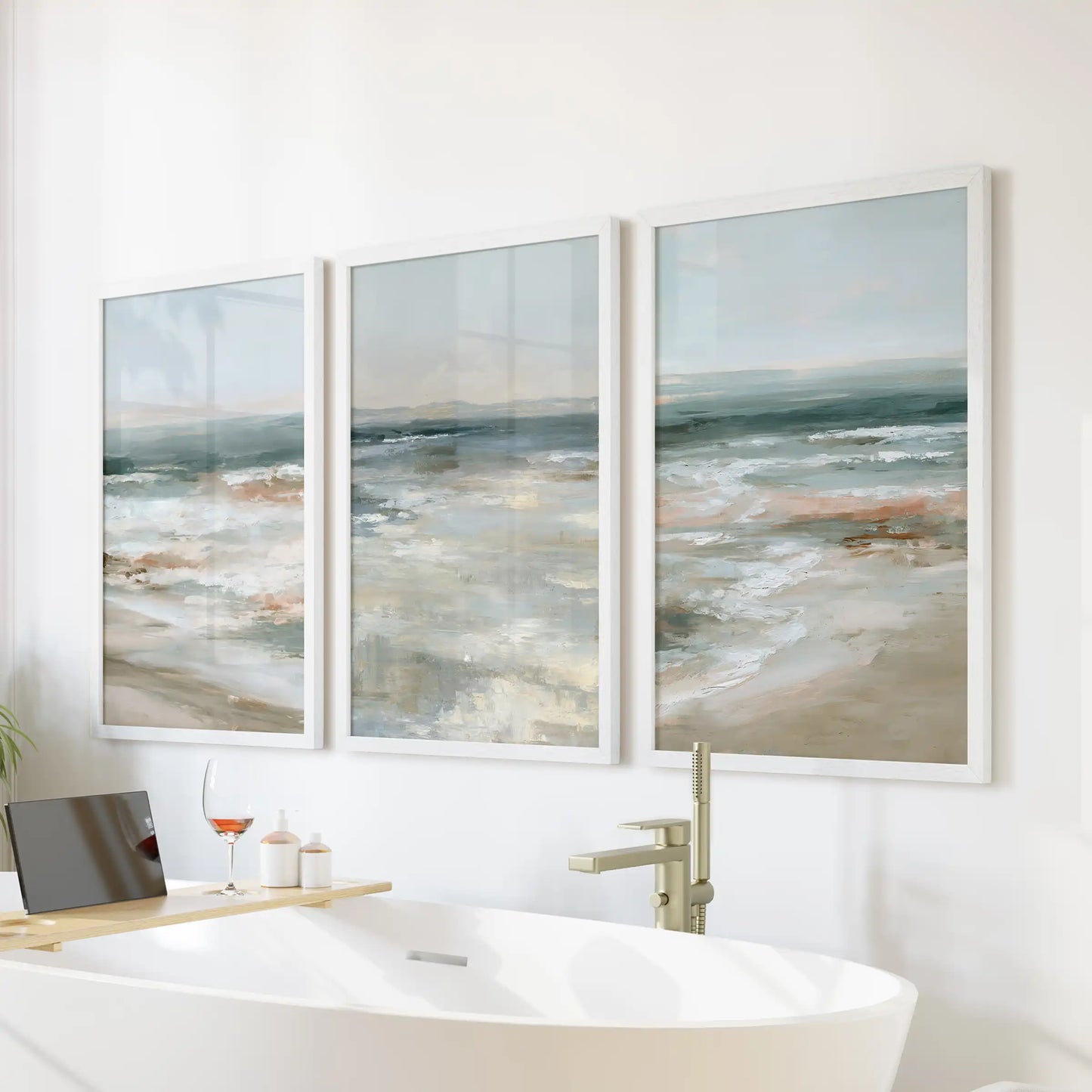 A trio of white-framed water prints forms serene wall decor above the bathtub, lending the bathroom a spa-like calm and openness.