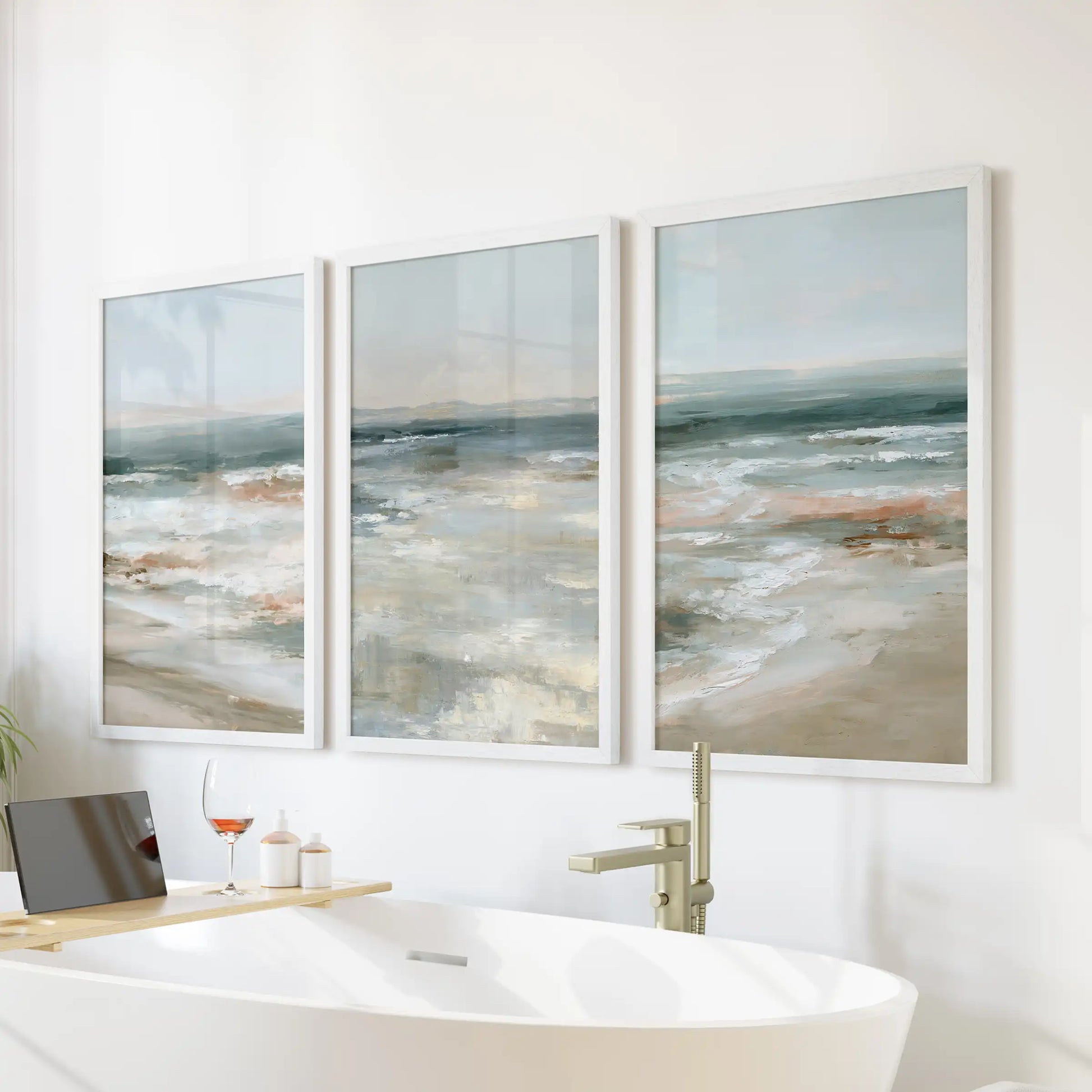 A trio of white-framed water prints forms serene wall decor above the bathtub, lending the bathroom a spa-like calm and openness.