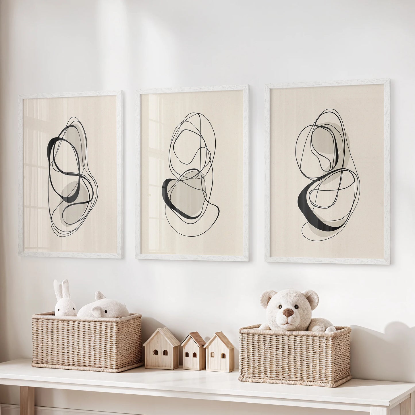 Scandinavian neutral prints, sets of 3 pictures in white frames, hung above toy storage to lend a tidy, modern note to a children’s room.