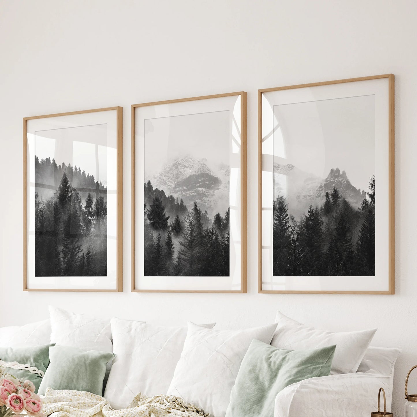 Three oak-matted wall pictures of misted forest peaks compose a balanced feature behind a sitting-room couch.