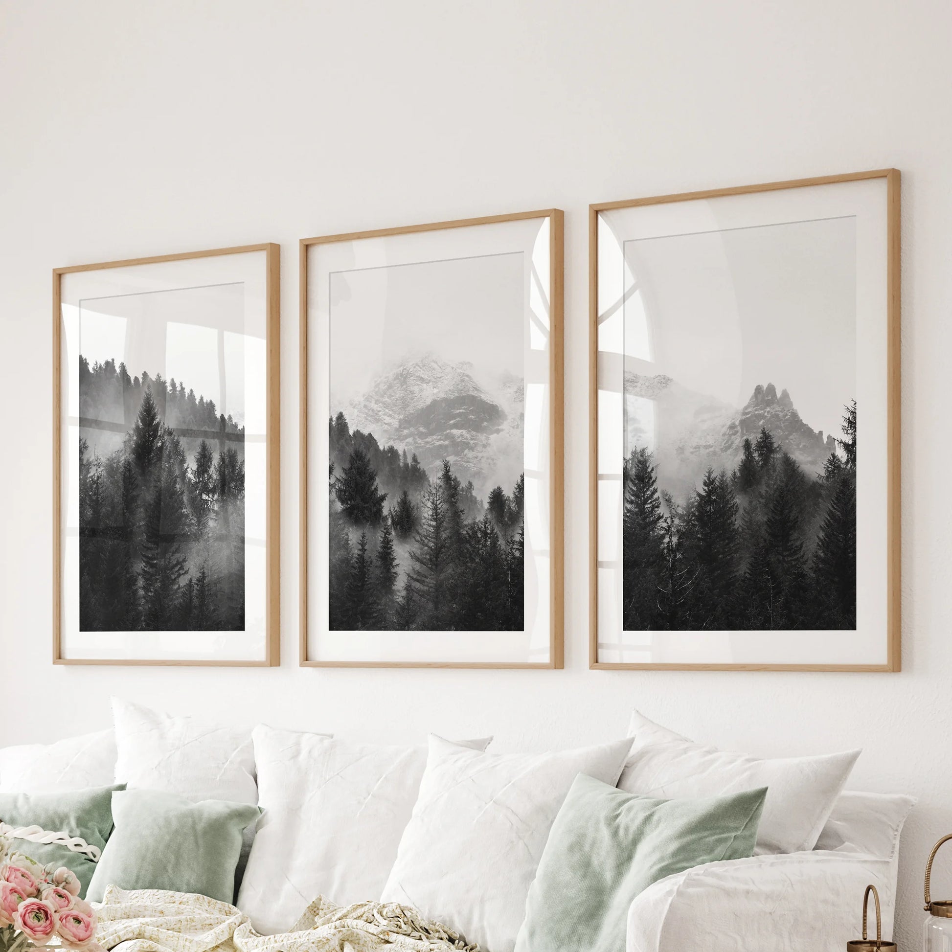Three oak-matted wall pictures of misted forest peaks compose a balanced feature behind a sitting-room couch.