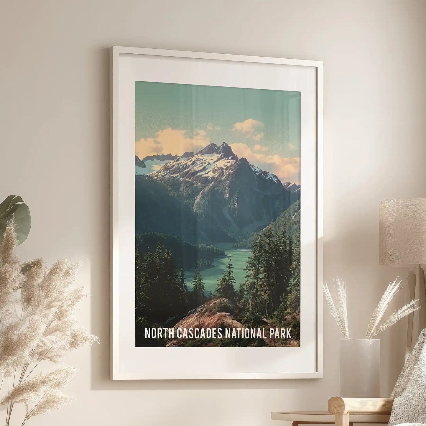 White-framed and matted wall art of Washington’s alpine wilderness hangs over a family room sofa, showing steep peaks and dense fir forests.