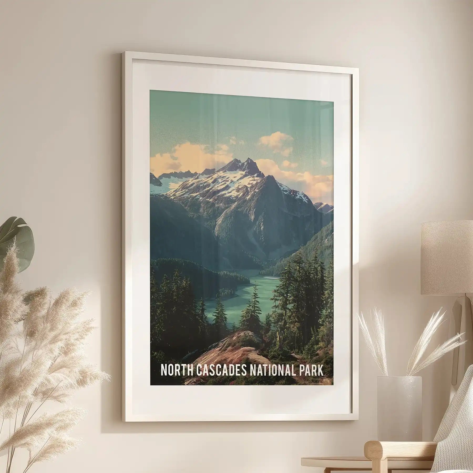 White-framed and matted wall art of Washington’s alpine wilderness hangs over a family room sofa, showing steep peaks and dense fir forests.