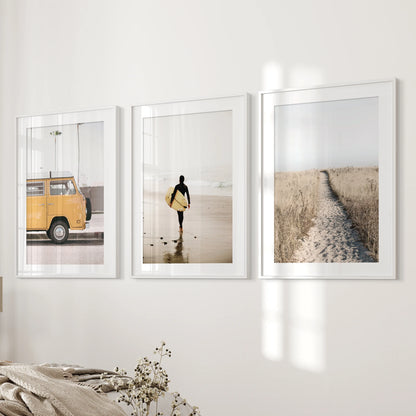 Wall art of three ocean vista prints, matted and framed in white, mounts beside the bed for a light, open feel in the bedroom.