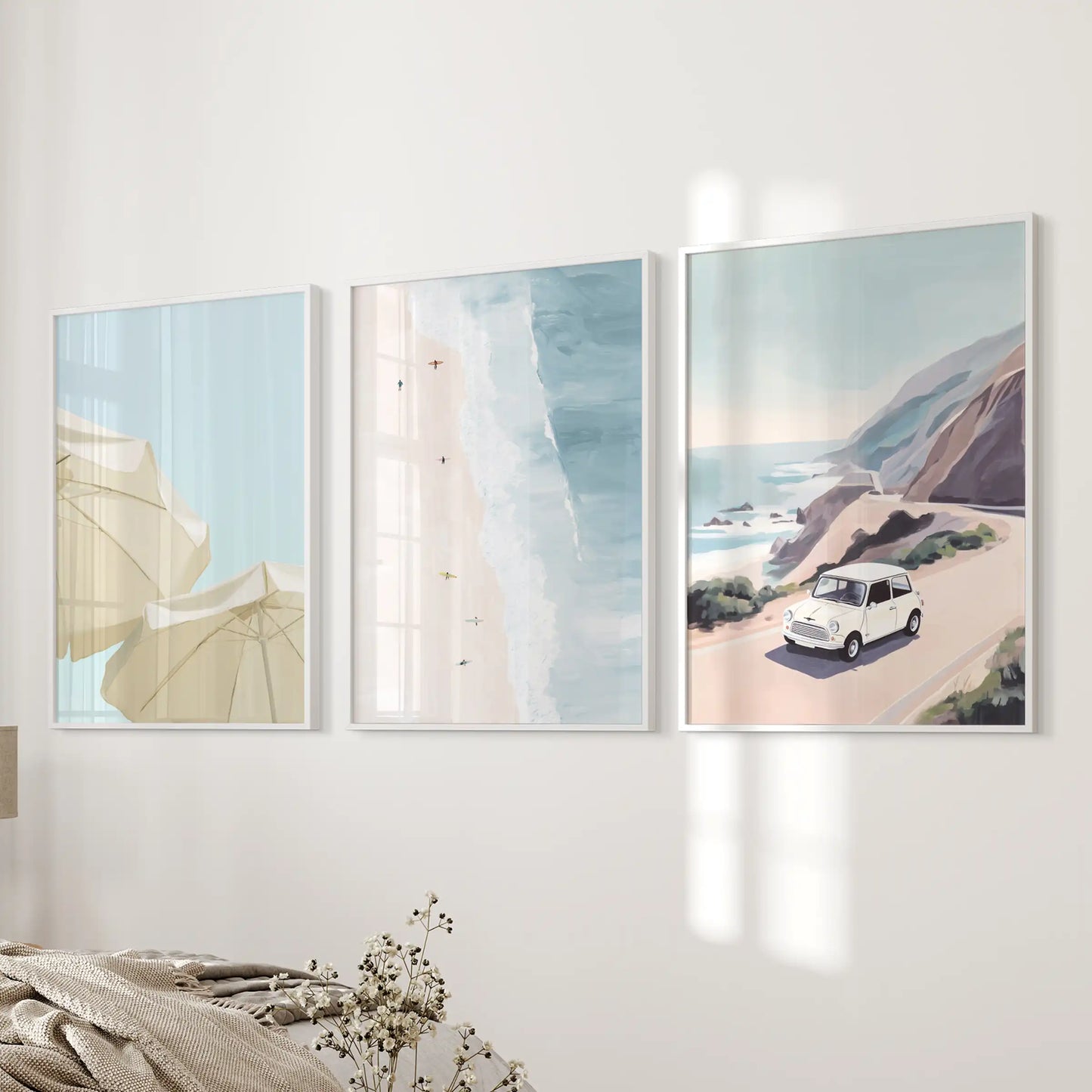 A trio of white-framed coastal road trip prints adds sunny wanderlust to the bedroom’s bedside wall.