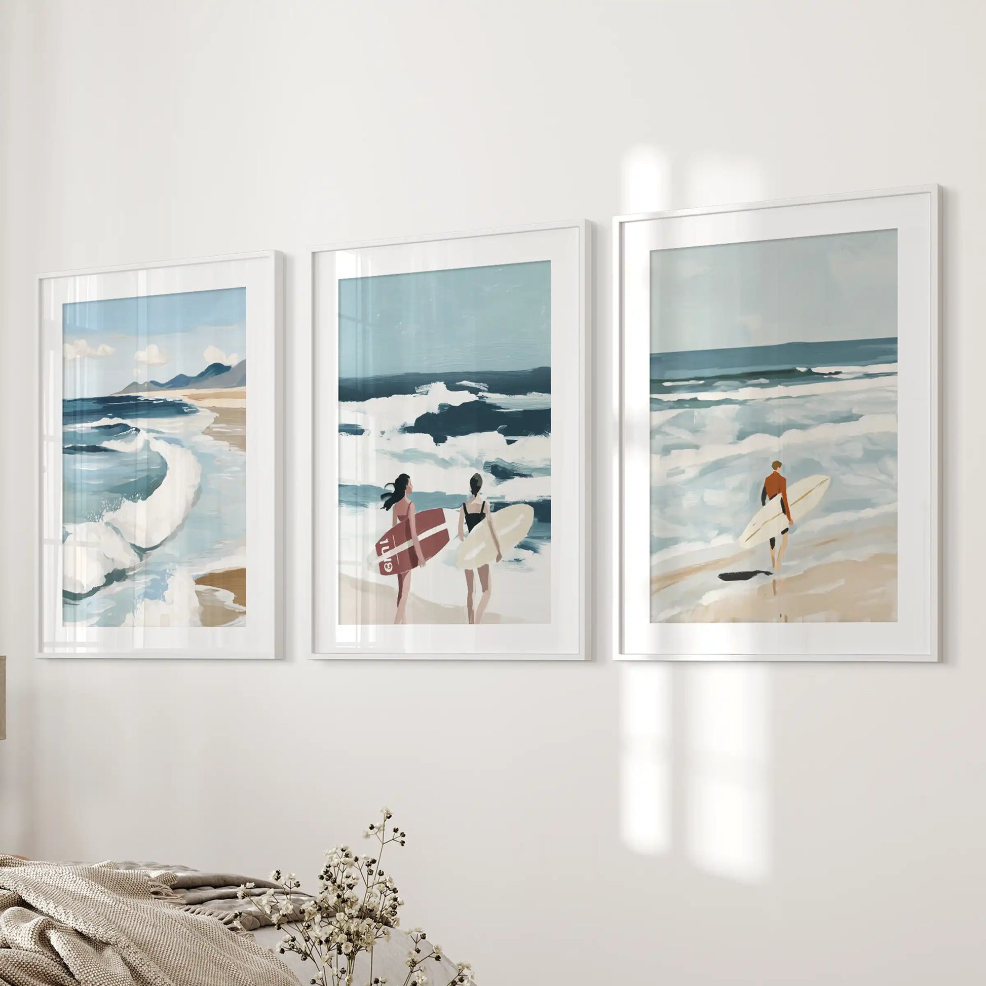 Ocean waves three-piece wall art in white frames with white mats, hung beside the bed to soothe a serene bedroom.