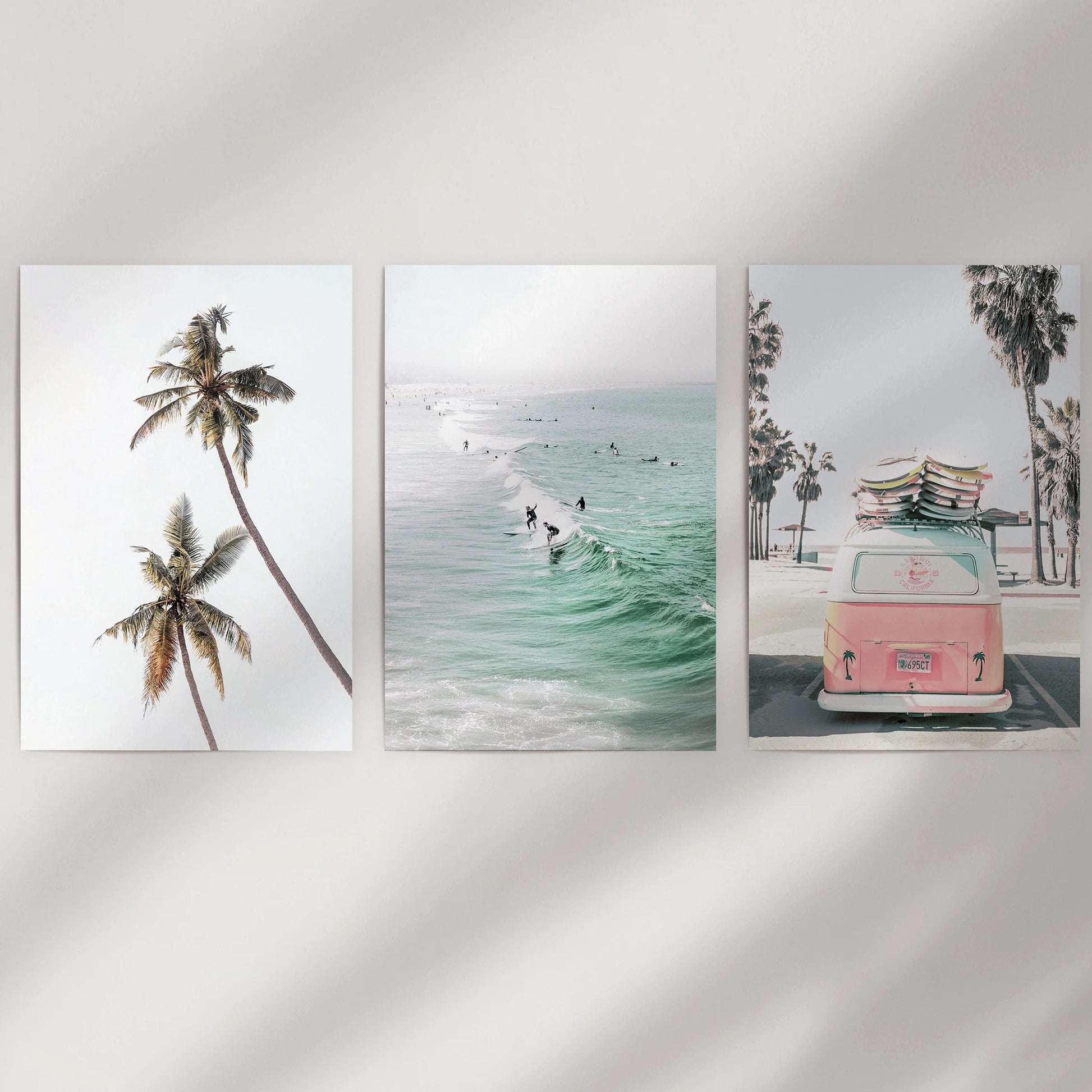 Unframed seaside wall art in three prints offers a clean, modern look across a white dining-room wall for an airy coastal touch.