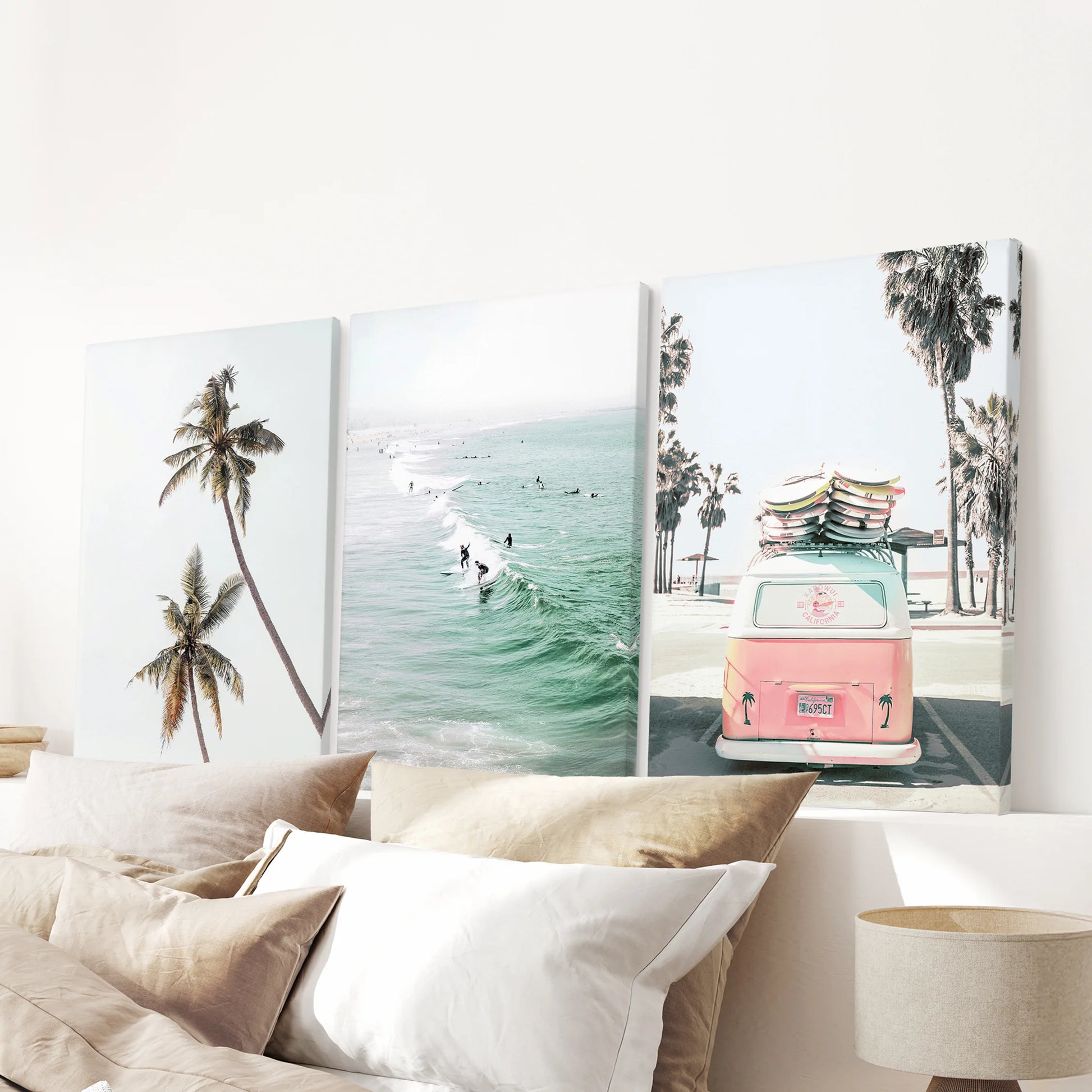 Gallery-wrapped ocean wave canvases come in a calm three-piece arrangement above the bed headboard, bringing a serene coastal mood.