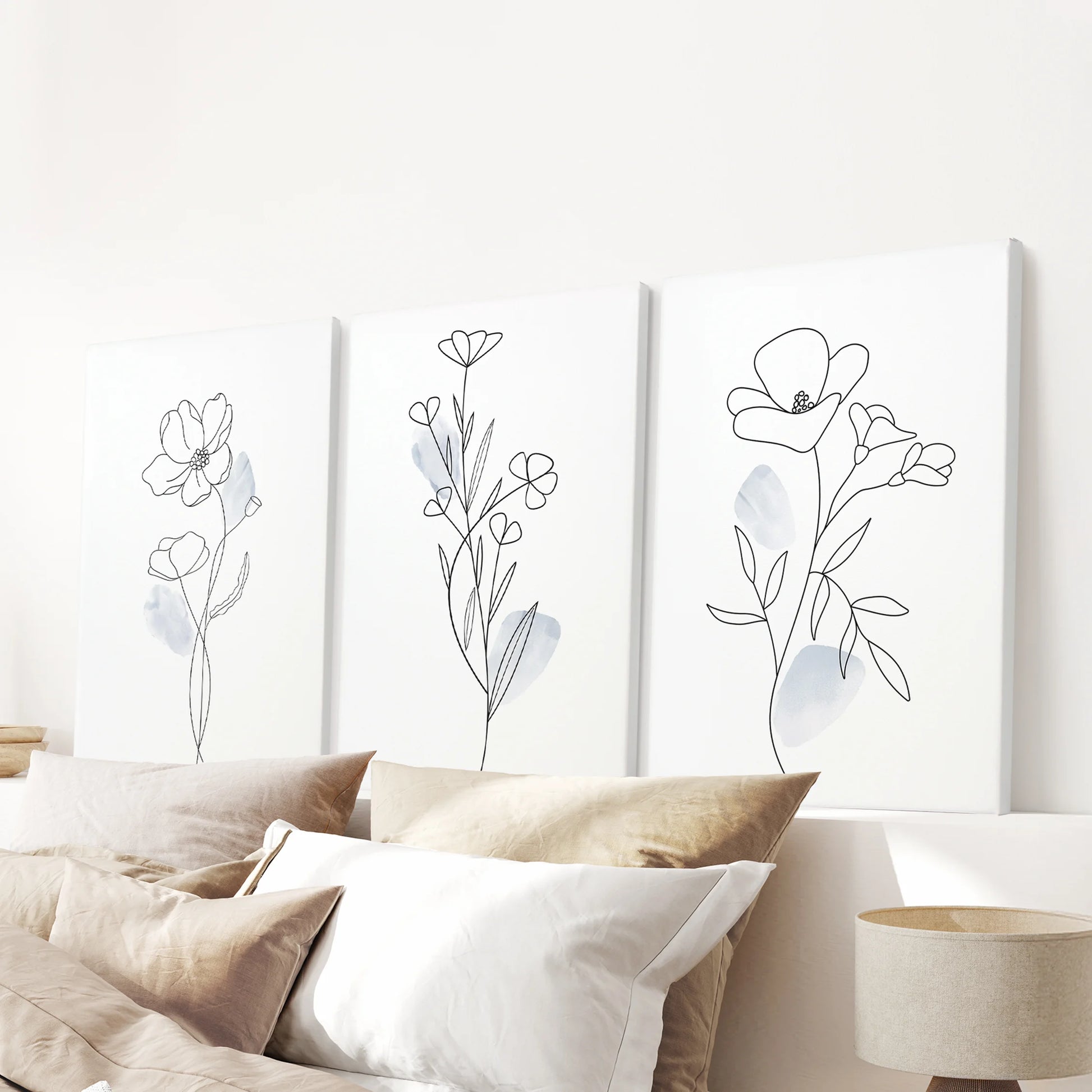 Pastel blue watercolor flowers, 3-print gallery wall on wrapped canvases, stretches over the bedroom headboard with tranquil, modern style.