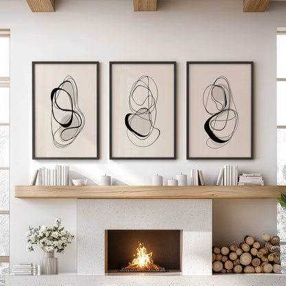 A three-piece wall decor set of minimalist one-line drawings in black frames, bringing clean black and beige contrast above a lounge mantel.