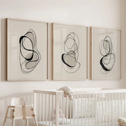 Three-print wall set of minimalist line illustrations in oak frames, placed above the bassinet to invite gentle contrast in the baby room.